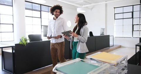 Smiling Business Colleagues Discussing Work in Modern Office