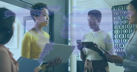 Diverse Women Collaborating in Modern Office with World Map Projection