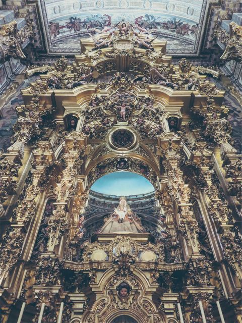 Featuring a grand Baroque church interior adorned with lavish golden gothic elements. Suitable for use in articles about historical architecture, religious art, and cultural heritage. Ideal for illustrating travel blogs, historical studies, and design inspirations.