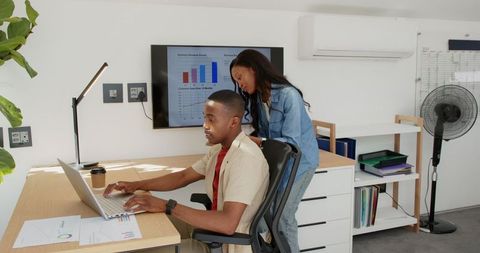 Coworkers collaborating on business project in modern office