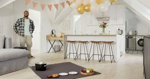 Man Preparing Anniversary Party with Food and Balloons