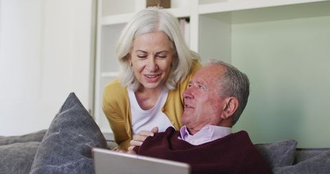 Senior Couple Using Laptop Across Generations in Living Room