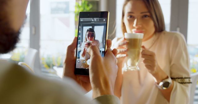 Man Photographing Woman Drinking Coffee in Cafe - Download Free Stock Images Pikwizard.com