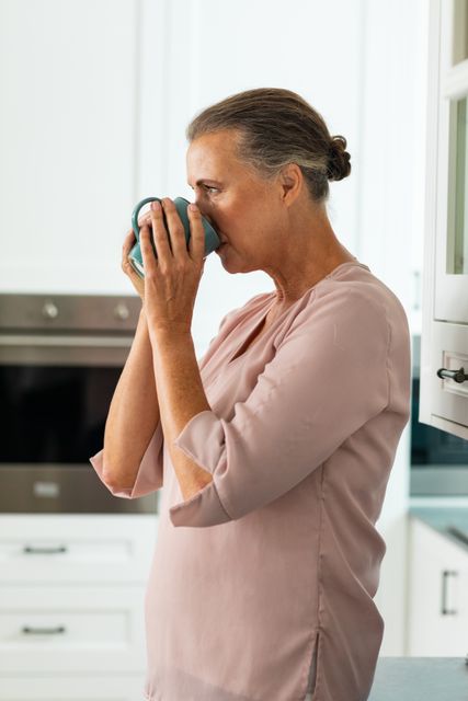 Side view of caucasian senior woman drinking coffee at home. unaltered, lifestyle, domestic life, retirement, drink, refreshment.