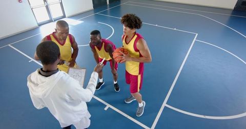 Basketball team engaged in strategy session during timeout