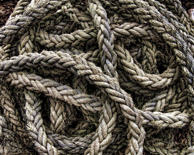 Rough, braided ropes tangled together forming a complex pattern. Suitable for maritime, nautical themes. Provides an industrial, rustic aesthetic useful for backgrounds, textures, and design materials stressing on nature or manual craft.