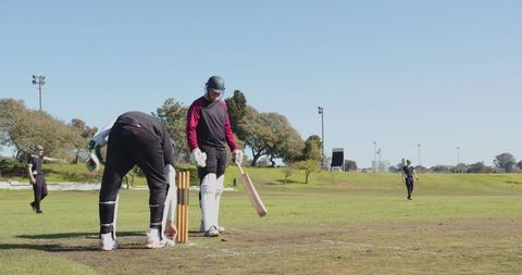 Cricket players preparing next ball on outdoor field
