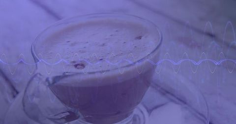 Frothy coffee in glass cup with abstract waveform overlay