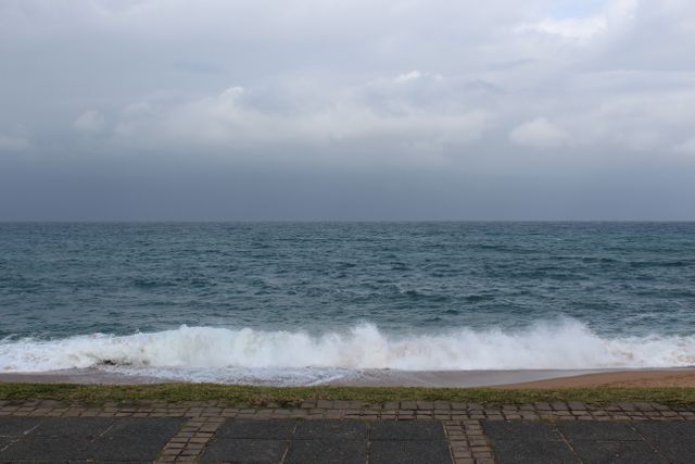 Calm Ocean Waves and Empty Beach Under Cloudy Sky - Download Free Stock Photos Pikwizard.com