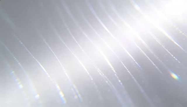 Iridescent diagonal streaks shimmering with luminous bokeh and glass-like gradient
