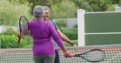 Senior Couple Embracing on Tennis Court Bright Day