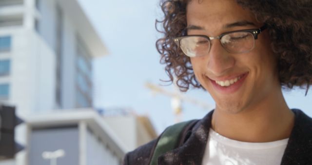 Smiling Young Man Walking Outdoors With Glasses and Curly Hair - Download Free Stock Images Pikwizard.com