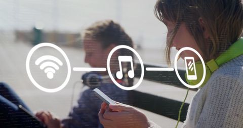 Girls using electronic devices with digital connectivity icons