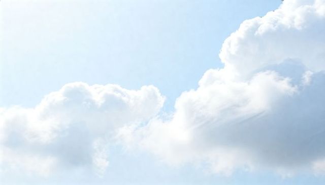 Sunlit cumulus clouds drifting over pale blue sky with soft shadows and airy atmosphere