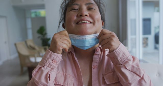 Portrait of asian female patient wearing face mask, lowering mask and smiling to camera. medicine, health and healthcare services during coronavirus covid 19 pandemic.