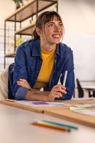 Creative professional smiling and drafting ideas in modern office