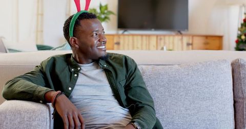 Joyful Man Wearing Reindeer Antlers Relaxing During Holiday Season