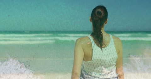 Tranquil Woman Gazing at Ocean Waves on Sunny Beach
