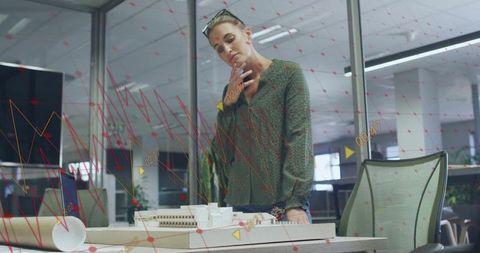 Architect analyzing scale model in modern office environment