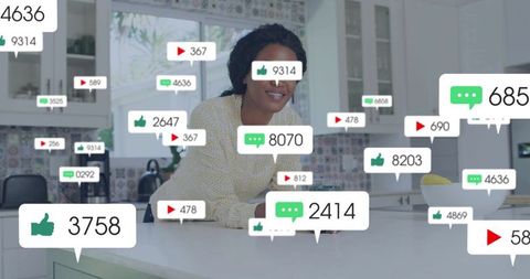 Black woman influencer leaning on white kitchen island smiling with social engagement icons overlay