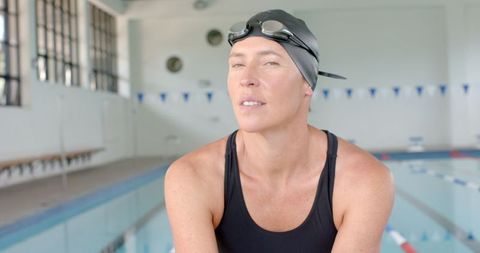 Confident Female Swimmer Preparing for Training in Indoor Pool