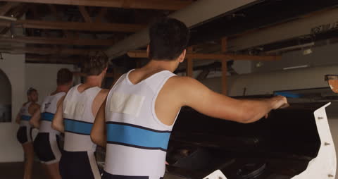 Team of Rowers Storing Boat in Boathouse after Practice