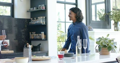 African American friends chatting at modern kitchen island during casual indoor gathering