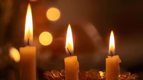 Flickering trio of pillar candles dripping wax into metal holder, casting warm bokeh glow