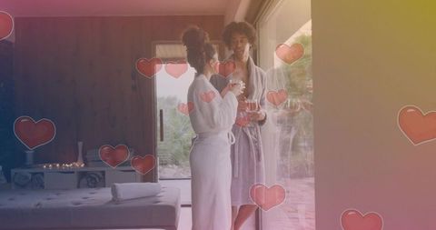Couple in bathrobes sharing morning drinks in luxury spa suite with romantic heart overlay
