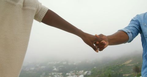 Couple Holding Hands on Foggy Beach Walk