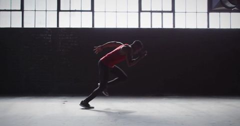 Athlete sprinting in industrial gym for speed and fitness training