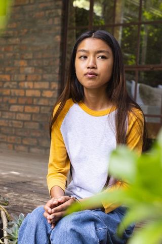 Teenage Girl Reflecting on Porch in Rustic Outdoor Setting
