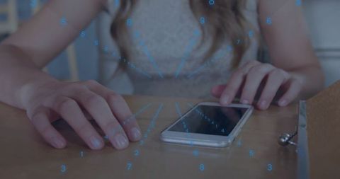 Resting hands near smartphone with digital data overlay, woman at wooden table