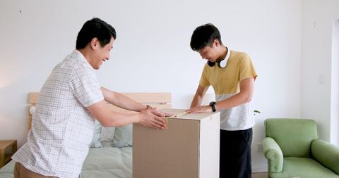 Father and son packing box with teamwork and smiles