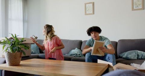 Young couple unpacking boxes in modern living room