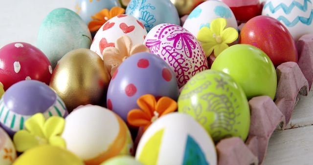 Colorfully decorated eggs are arranged in a carton, showcasing a variety of patterns and designs for Easter celebration. These vibrant eggs reflect a festive tradition of egg decoration during the Easter season.