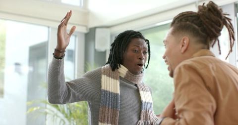 Expressing surprise and excitement during friendly conversation in sunlit modern living room