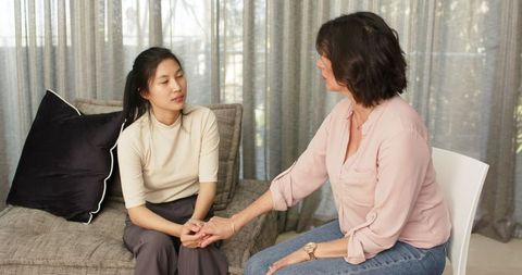 Therapist and patient holding hands during consoling session