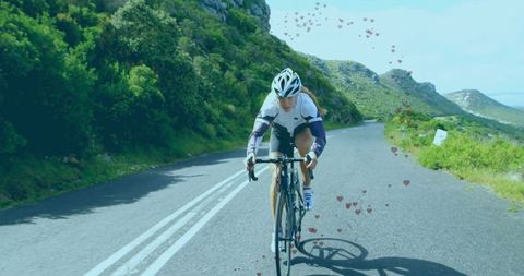 Female Cyclist Pedaling Uphill on Scenic Mountain Road