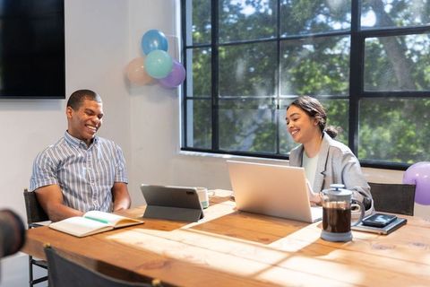 Coworkers Collaborating at Wooden Table in Modern Office