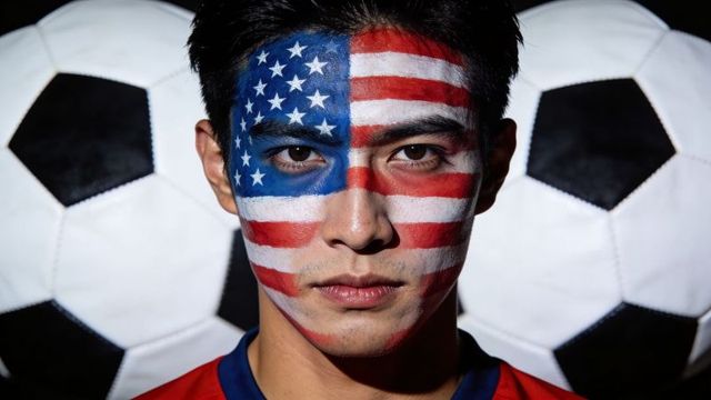 American soccer fan wearing usa flag face paint, intense portrait with soccer balls
