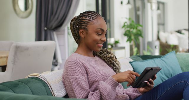 Smiling African American Woman Using Tablet in Modern Living Room - Download Free Stock Images Pikwizard.com