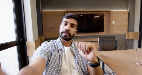 Confident Businessman in Modern Office Using Smartwatch During Meeting