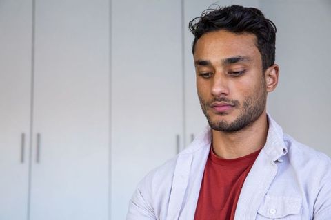 Contemplative man in casual attire inside minimalist room