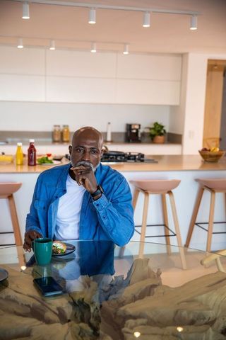 Senior Man Drinking Coffee in Modern Kitchen Setting