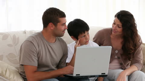 Family Bonding Together on Sofa with Laptop