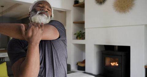 Senior male stretching for wellness in modern minimalist living room