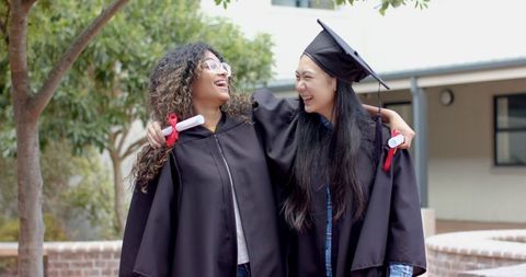 Two Friends Celebrating Graduation Day in Caps and Gowns Outdoors - Download Free Stock Images Pikwizard.com
