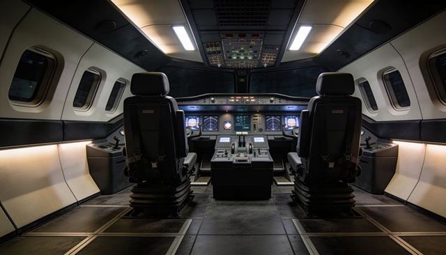 Business jet cockpit featuring dual pilot seats, advanced avionics and backlit flightdeck