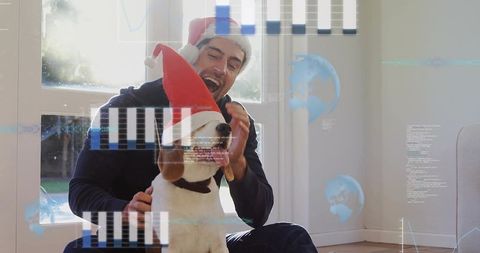 Man and dog wearing santa hats with digital holiday overlays in bright living room